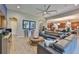 Open concept living room features a large sectional sofa, decorative art pieces, and a ceiling fan at 6016 Shadowlake Dr, Apollo Beach, FL 33572