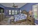 Spacious primary bedroom with large bed, bench, herringbone floors, and plenty of natural light at 6016 Shadowlake Dr, Apollo Beach, FL 33572