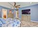 Spacious main bedroom features a large bed with blue floral bedding, and herringbone-patterned floors at 6016 Shadowlake Dr, Apollo Beach, FL 33572