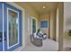 Inviting front porch featuring comfortable seating, a stylish blue door, and a welcoming ambiance at 6016 Shadowlake Dr, Apollo Beach, FL 33572