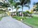 Well-manicured front yard with a brick paver driveway and lush landscaping surrounding the home at 6801 S Sparkman St, Tampa, FL 33616