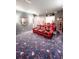 Home theater room featuring red, diamond-patterned leather seating and movie-themed carpet at 6801 S Sparkman St, Tampa, FL 33616