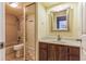 Bathroom with vanity, wood cabinet, large mirror, and combination shower and bathtub at 705 1St Ct, Palm Harbor, FL 34684
