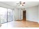 Bright bedroom with wood floors, ceiling fan, and balcony access at 705 1St Ct, Palm Harbor, FL 34684