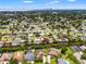 An aerial view of a waterfront residential neighborhood, lush with trees, with a city skyline on the far horizon at 715 45Th Ne Ave, St Petersburg, FL 33703