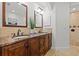 Bathroom featuring double sinks, granite counters, wood cabinetry, and tiled floors at 715 45Th Ne Ave, St Petersburg, FL 33703
