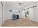 Bedroom with wood floors, ceiling fan, and sliding barn doors to a closet at 715 45Th Ne Ave, St Petersburg, FL 33703