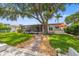 Charming home exterior showcasing a screened lanai, outdoor kitchen, mature landscaping, and pathway to the waterfront at 715 45Th Ne Ave, St Petersburg, FL 33703