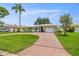 Inviting home boasts a red brick driveway, tidy landscaping, and an attached garage, perfect for suburban living at 715 45Th Ne Ave, St Petersburg, FL 33703