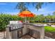 Outdoor kitchen featuring modern stainless steel grill, counterspace and cabinetry, under a bright umbrella, perfect for outdoor cooking at 715 45Th Ne Ave, St Petersburg, FL 33703