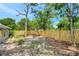 View of the backyard featuring a new wooden fence and mature trees at 7411 Seashore Dr, Port Richey, FL 34668