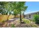 View of the backyard featuring a new wooden fence, mature trees, and home exterior at 7411 Seashore Dr, Port Richey, FL 34668