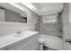 Charming bathroom featuring a gray tile shower, wood look floors, and ample lighting for a spa-like experience at 7411 Seashore Dr, Port Richey, FL 34668
