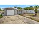 Exterior view of a gray home with a red front door and a large front driveway at 7411 Seashore Dr, Port Richey, FL 34668