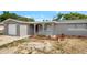 Exterior view of a gray home with a red front door and an attached garage at 7411 Seashore Dr, Port Richey, FL 34668