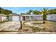 Exterior view of a gray home with a red front door and a front lawn at 7411 Seashore Dr, Port Richey, FL 34668