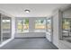 Bright sunroom with multiple windows providing natural light and views of the fenced backyard at 7411 Seashore Dr, Port Richey, FL 34668
