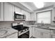 Updated kitchen with granite countertops, stainless steel appliances, and modern fixtures at 7411 Seashore Dr, Port Richey, FL 34668
