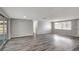 Spacious living room with hardwood floors, a large window, and fresh paint at 7411 Seashore Dr, Port Richey, FL 34668
