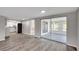 Bright living room view with wood flooring, sliding glass doors, and kitchen area at 7411 Seashore Dr, Port Richey, FL 34668