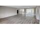 Bright living room with wood flooring and sliding glass doors to enclosed patio, freshly painted at 7411 Seashore Dr, Port Richey, FL 34668