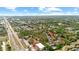 Aerial shot of a residential area with lush green trees, a road, and condominium buildings with red roofs at 7741 Forest Trl # 6, Port Richey, FL 34668