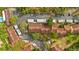 Aerial view of a neighborhood with multiple condominium buildings featuring a parking lot and surrounded by trees at 7741 Forest Trl # 6, Port Richey, FL 34668