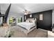 Modern bedroom featuring a black accent wall, a ceiling fan, and a large window with natural light at 7741 Forest Trl # 6, Port Richey, FL 34668