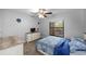 Comfortable bedroom featuring a ceiling fan, a patterned blue and white bedspread, and large window at 7741 Forest Trl # 6, Port Richey, FL 34668