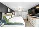 Spacious bedroom featuring a black accent wall, a large TV, and neutral carpet with bright natural light at 7741 Forest Trl # 6, Port Richey, FL 34668