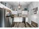 Bright and spacious kitchen with stainless steel appliances, herringbone backsplash, and stylish lighting at 7741 Forest Trl # 6, Port Richey, FL 34668
