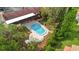 Aerial view of a community pool surrounded by lush landscaping, lounge chairs, and covered patio seating at 7741 Forest Trl # 6, Port Richey, FL 34668