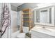 Bright bathroom with a shower/tub combo, wooden shelving, and clean vanity at 8220 12Th N Way # G, St Petersburg, FL 33702