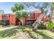 Exterior facade of red brick apartment building with mature trees and landscaping at 8220 12Th N Way # G, St Petersburg, FL 33702