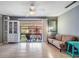 Bright living room featuring a ceiling fan and sliding glass doors to outdoor screened balcony at 8220 12Th N Way # G, St Petersburg, FL 33702