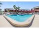 Community pool featuring clear blue water, lounge chairs, and a white picket fence, surrounded by red brick buildings at 8220 12Th N Way # G, St Petersburg, FL 33702