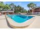 Community swimming pool with a pool house, white fence, and several trees at 8220 12Th N Way # G, St Petersburg, FL 33702