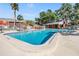 Resort-style swimming pool featuring lounge chairs, palm trees, and nearby community buildings, perfect for relaxation at 8220 12Th N Way # G, St Petersburg, FL 33702