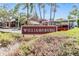 Community entrance sign for Williamsburg surrounded by greenery at 8220 12Th N Way # G, St Petersburg, FL 33702