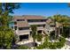 Front exterior of raised beach home featuring covered parking and lush tropical landscaping at 8226 W Gulf Blvd # 2, Treasure Island, FL 33706