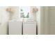 Bright laundry room features a modern washer and dryer, shelving, and a window for natural light at 8433 Sea Ray Run, Parrish, FL 34219