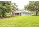 Expansive backyard with lush lawn, mature trees, and a screened-in porch at 8444 Shenandoah Run, Wesley Chapel, FL 33544