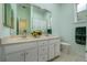 Bathroom with double sink vanity, white cabinets, large mirror, and a separate toilet room at 8444 Shenandoah Run, Wesley Chapel, FL 33544