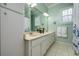 Bathroom features double sink vanity with white cabinets, a large mirror, and a shower-tub combo at 8444 Shenandoah Run, Wesley Chapel, FL 33544