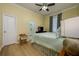 Comfortable bedroom with wood-look floors, neutral walls, a ceiling fan, and ensuite bathroom access at 8444 Shenandoah Run, Wesley Chapel, FL 33544