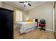 Cozy bedroom with hardwood floors, a window with sheer curtains, and a dark wardrobe at 8444 Shenandoah Run, Wesley Chapel, FL 33544
