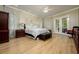 Serene main bedroom suite with a king-size bed, hardwood floors, and access to the outdoors at 8444 Shenandoah Run, Wesley Chapel, FL 33544