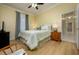 Bedroom with wood-look floors and green bedding, leading to a hallway and bathroom at 8444 Shenandoah Run, Wesley Chapel, FL 33544
