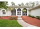 Inviting front entrance with charming arched doorways, lush landscaping, and a walkway at 8444 Shenandoah Run, Wesley Chapel, FL 33544