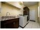 Functional laundry room with sink, storage cabinets, and modern washer and dryer units at 8444 Shenandoah Run, Wesley Chapel, FL 33544